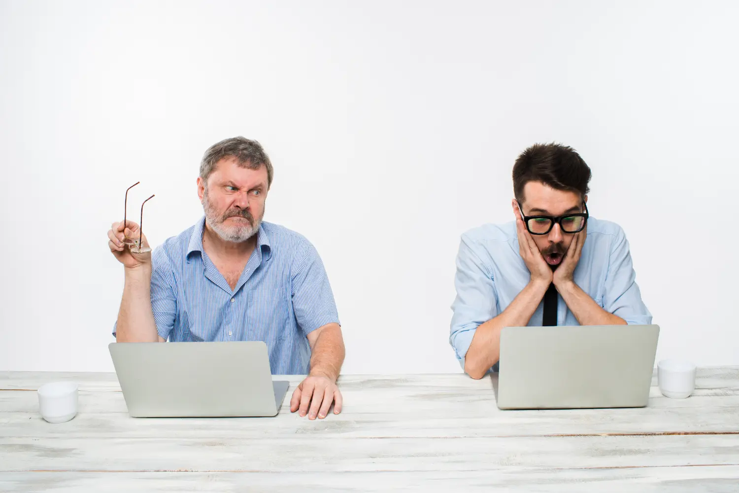 two professionals looking at the same task on a computer screen with puzzled expressions.